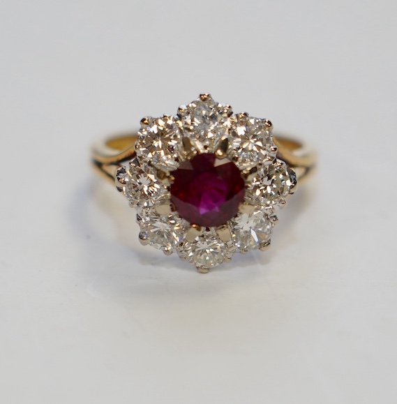 An 18ct gold, single stone ruby and eight stone diamond set flower head cluster ring, size P, gross weight 6.5 grams. Condition - fair